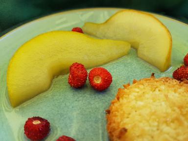 A pear poached in lavender and wine and served with forest strawberries and a coconut macaroon.